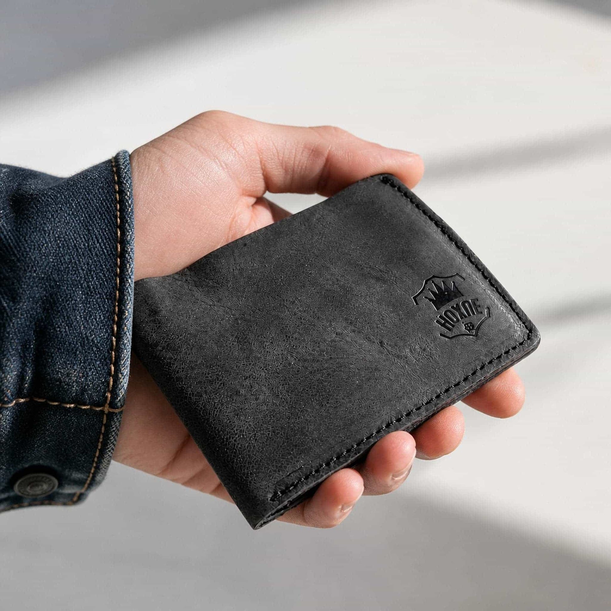 Hand holding Hoxne Leather bifold wallet, full-grain leather