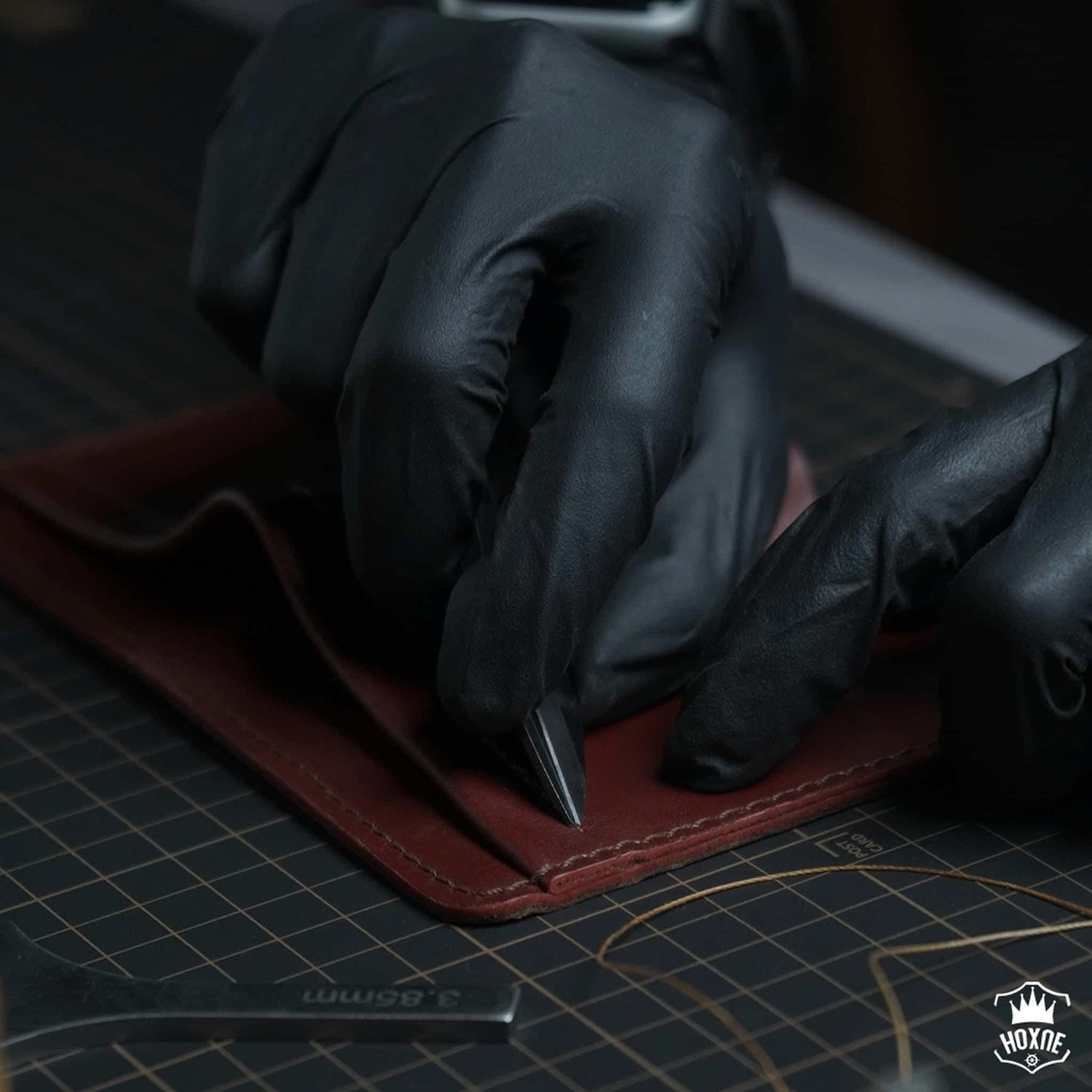 Hoxne Leather artisan hand-finishing a genuine leather bifold wallet in the workshop