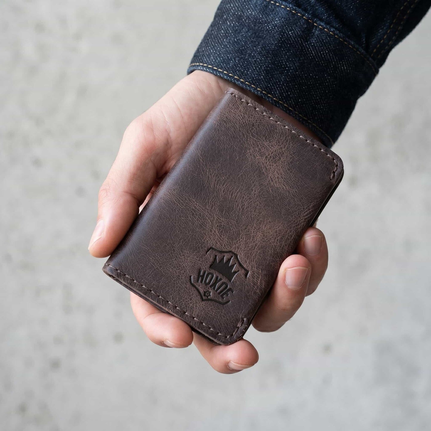 Hand holding Hoxne Leather minimalist card holder, full-grain
